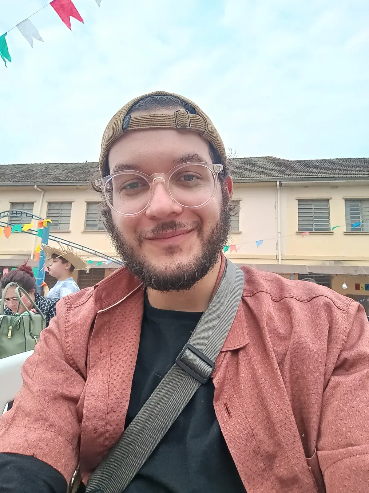 A selfie of Bruno in a cap and glasses at an outdoor festival.