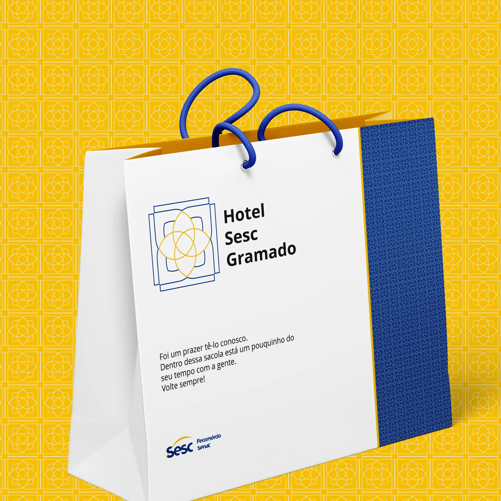 The paper bag against a yellow ground patterned with the mark.